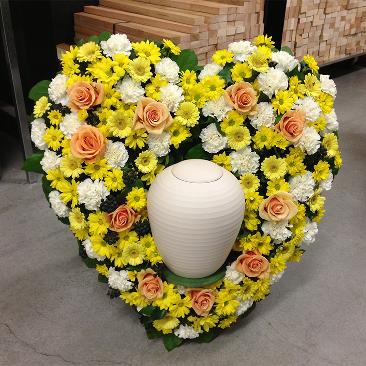 "die urne" von Urne.ch mit herzförmigem Blumenschmuck